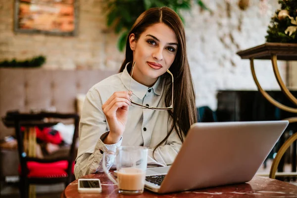 Retrato Mulher Bonita Segurando Óculos Enquanto Sentado Café Com Laptop — Fotografia de Stock