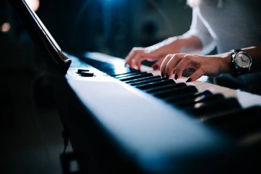 Bir kadın görmek oynarken piyano synhtesizer eller.