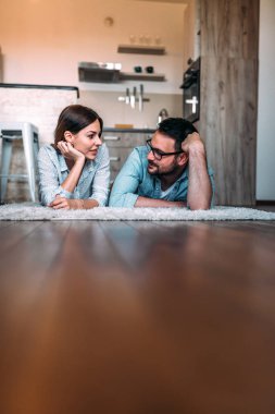 Genç çift daire yerde yatan süre konuşmak.