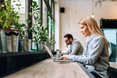 Sarışın kadın metin yazarı Café yaratıcı görev üzerinde çalışmaya konsantre.