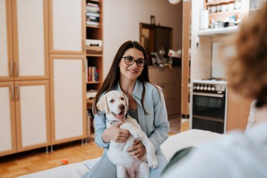 Arkadaş evinde konuşurken onu köpek tutan genç güzel kadın.