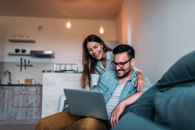 Dizüstü bilgisayarda komik bir şey izlerken Çift gülüyor.