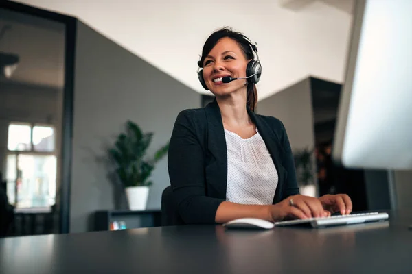 Beautiful call center consultant in headphones.