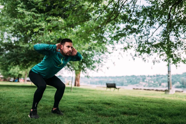 Full Length Young Concentrated Sportsman Doing Squats Outdoors — Stock Photo, Image