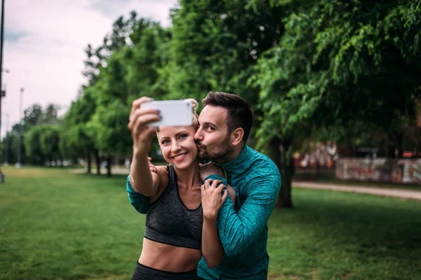 Sport, technology and healthy lifestyle concept. Couple making selfie after workout.