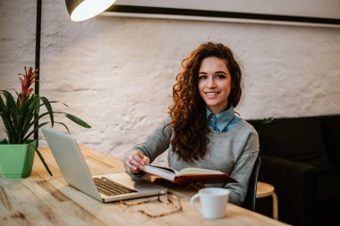 Genç kadının evde kitap okuma.