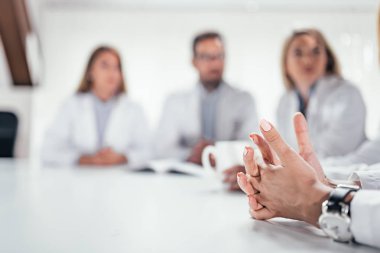 Masa başında iletişim doktorlar. Bir şey onu Arkadaşlarınıza açıklayan sırasında kadın doktorun elleri yakın çekim görüntüsü.