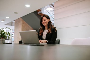 Dizüstü bilgisayar kullanan gülümseyen kadın. Kopya alanı.