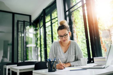 Genç öğrenci Not laptop ve kitaplardan kitaplığında almak.