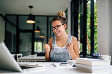 Genç Öğrenci Sınavı geçtikten. Dizüstü bilgisayar ekranına bakarak.