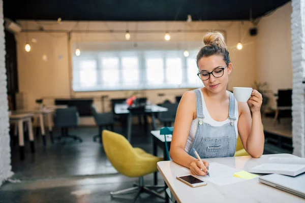 Junge Frau Schreibt Auf Papier Während Sie Eine Tasse Hält — Stockfoto