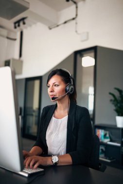 Yardım ve teknik destek kavramı. İş kadını ofiste bilgisayar önünde otururken arama yapma.