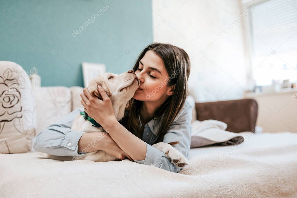 Yong woman having happy time with pet.