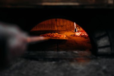 Odun ateşinde bir fırında pişirme pizza.
