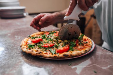 Yakın çekim yansıma el Şef baker kesme pizza.