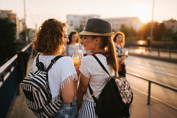 Two gorgeous girls having fun while walking to a music festival in the summer.