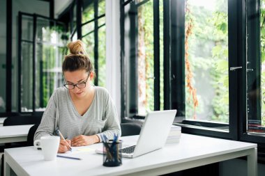 Kütüphanede okuyan genç kız öğrenci.