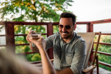 Şerefe! Yakın çekim görüntü iki insanın doğada balkonda kızartma.