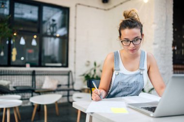 Notlar ve halka açık bir yerde içinde laptop ile eğitim genç kadın.