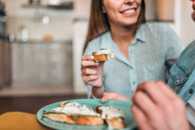 Yakın çekim yansıma çiftin evde sandviç yemek.