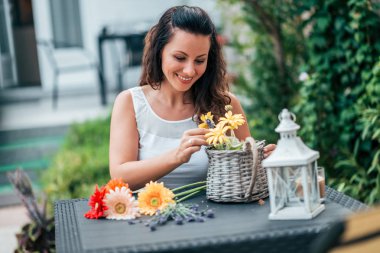 Genç kadın, ev bahçe çiçek sepeti yapma.