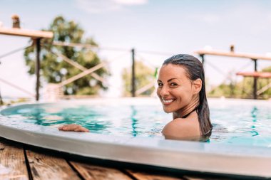 Yakın çekim yansıma yüzme havuzunda gerçek gülümseme ile esmer.