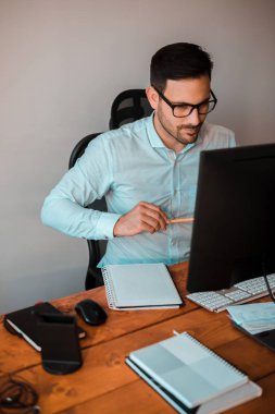 İlham için arama. Düşünceli genç adam ofis masa başında otururken fikirleri aşağı yazma .