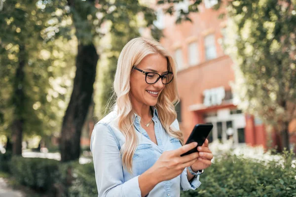 Close Imagem Mulher Loira Sorridente Olhando Para Smartphone Livre — Fotografia de Stock