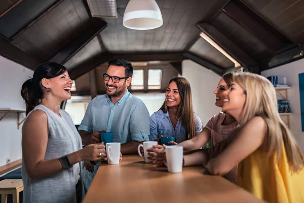 五个朋友一边笑一边喝茶或咖啡在柜台边 — 图库照片