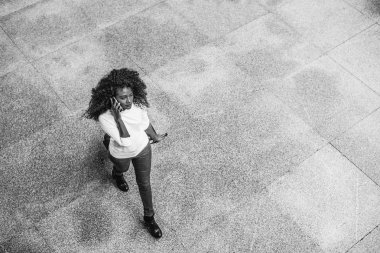 Genç Afro-Amerikan kadın havaalanında bavulu sürükleme.