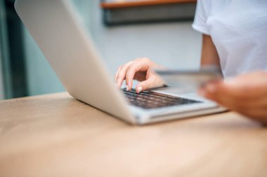 Laptop ve kredi kartı kullanan kadın yakın çekim görüntüsü. Online alışveriş kavramı.