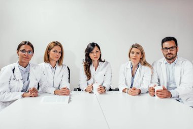 Hekimlerin konferans odasında otururken kameraya arıyoruz. Kopya alanı.