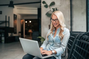 Güzel blogger lobisinde otururken çalışma.