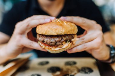 Lezzetli hamburger yeme. Yakın çekim.