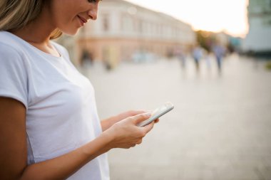 Şehirde telefon kullanan kız yakın çekim görüntüsü.
