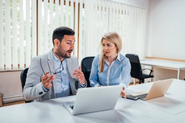 İki yöneticileri parlak ofiste çalışırken konuşmak.