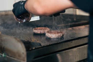 Bir ızgara fastfood restoranda hamburger hazırlama. Yakın çekim.
