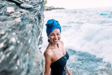 Dalgalar kayalar çökmesini önünde gerçek gülümseme ile muhteşem bir kadın.