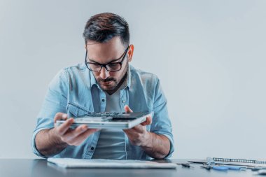 Dizüstü donanım kırık parçalar için teftiş. Dizüstü bilgisayar parçaları inceleyerek YAKIŞIKLI seriuous teknisyeni.