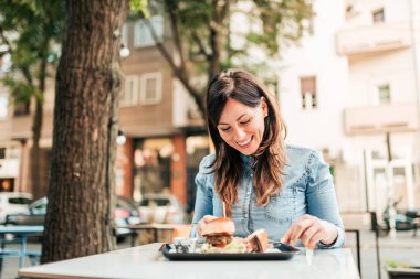 Açık havada fast food restoran yeme hamburger.