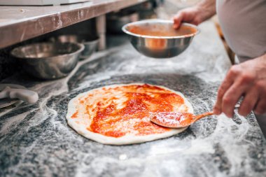 Pizza domates sosu ile temel hazırlık Şef yakın çekim görüntüsü.