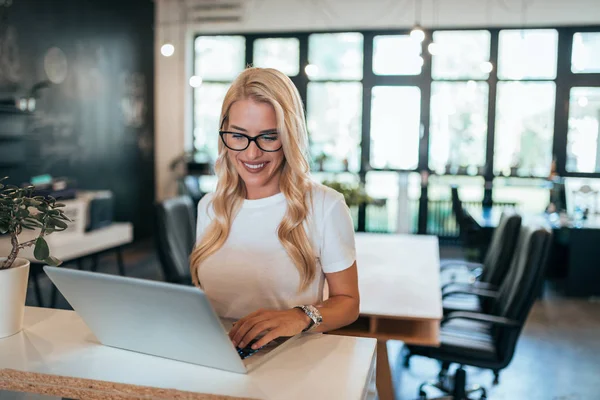 Young blonde woman working in creative studio.