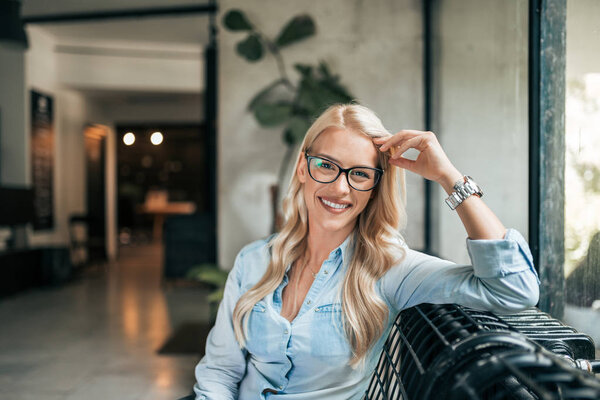 Portrait of a charming blonde lady indoors. Looking at camera.