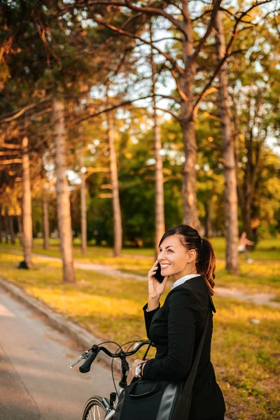 Mujer Sonriente Hablando Por Teléfono Mientras Pedalea —  Fotos de Stock