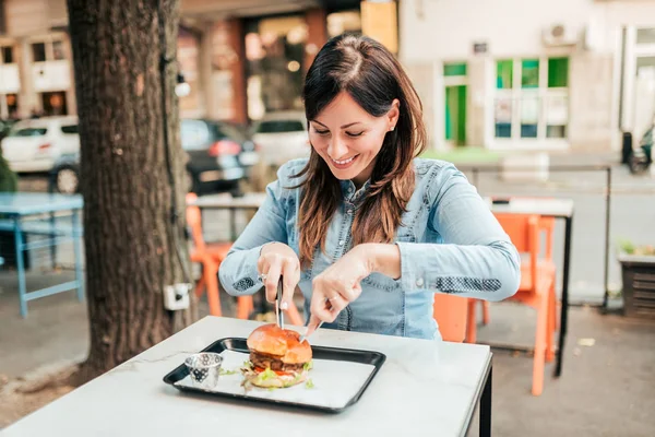 Sjarmerende Ung Kvinne Som Spiser Hamburger – stockfoto