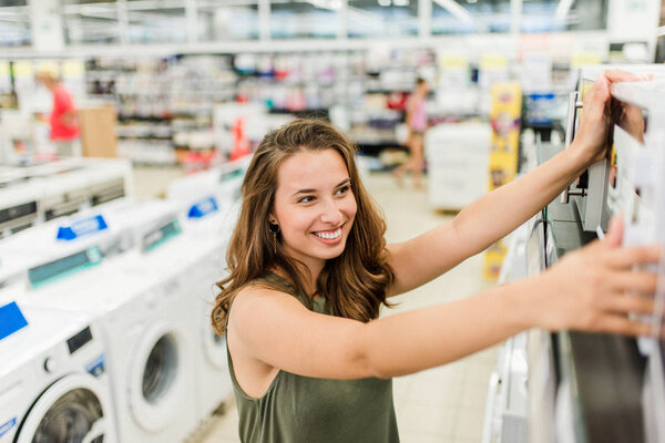 Женщина покупает микроволновку в магазине бытовой техники
.