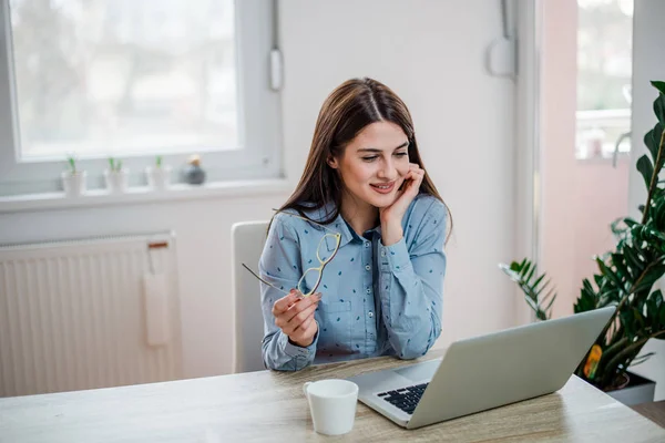 Retrato Mulher Bonita Segurando Espetáculo Sorrindo Sentado Mesa Frente Computador — Fotografia de Stock