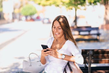 Casual gülümseyen genç kadın manifatura açık havada.