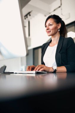 Güzel iş kadını bilgisayarda çalışan düşük açılı görüntü.