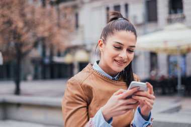 Akıllı telefon açık kullanan güzel genç kadın portresi yakın çekim.